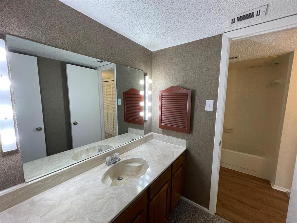 11480 Audelia Road, Unit 231 Dallas, TX 75243 - Photo 10 of 15 a bathroom with a granite countertop sink and a mirror
