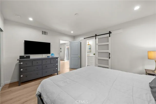 a bedroom with a bed and wooden floor