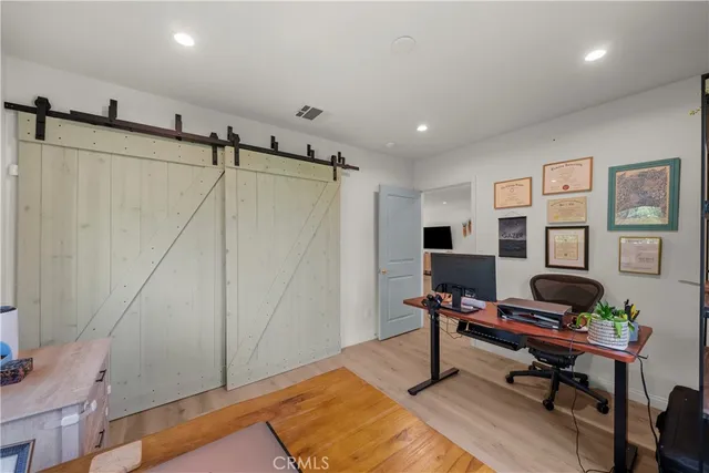 a view of a workspace with furniture and wooden floor