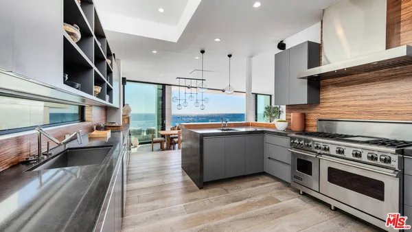 a kitchen with stainless steel appliances and wooden floor