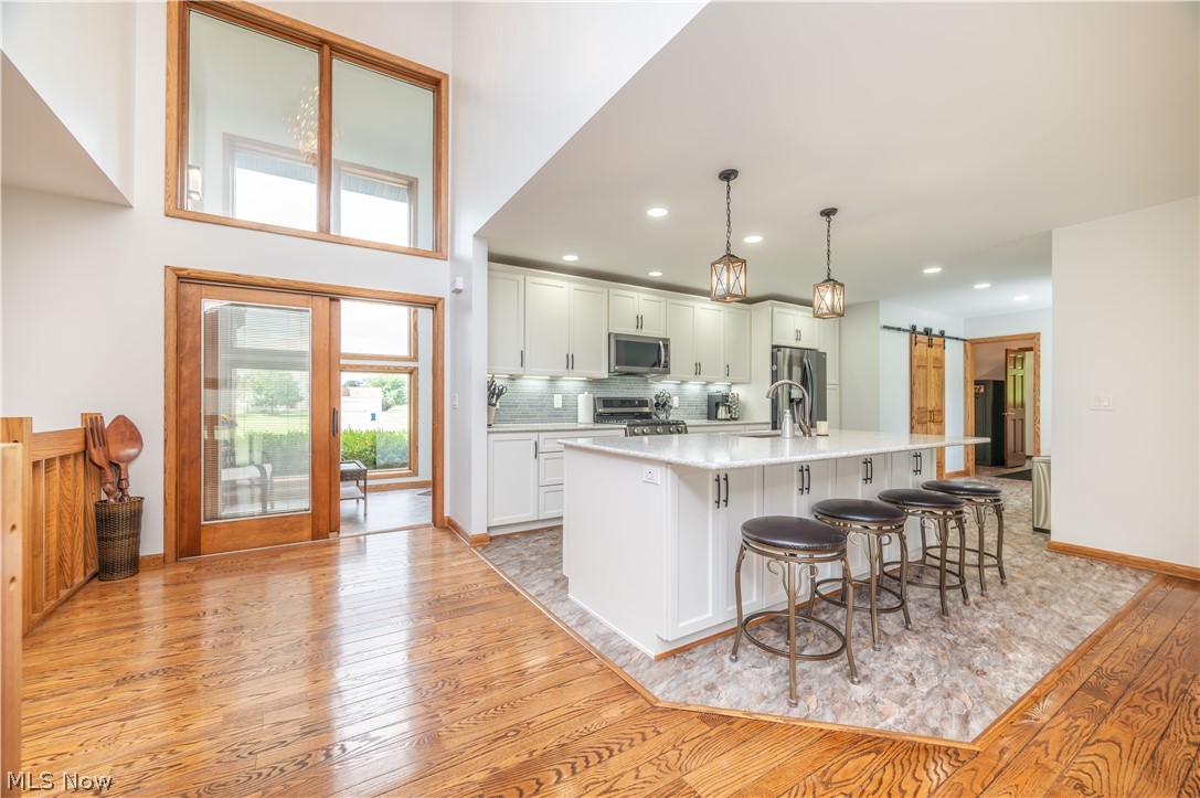 405 Airport Road Northwest Warren, OH 44481 - Photo 11 of 50 Kitchen featuring white cabinetry, a large center island with seating, pendant lighting, and stainless steel appliances
