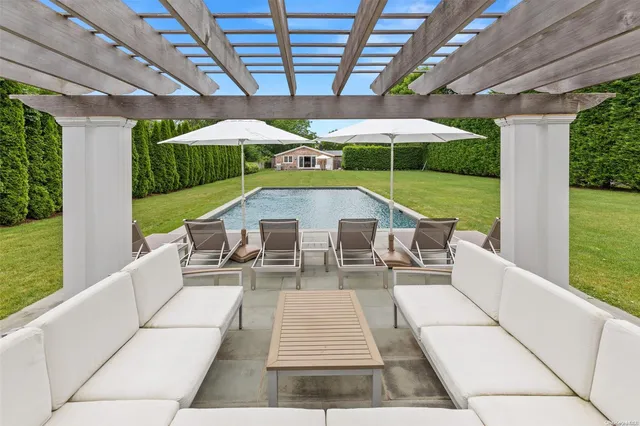 a view of a patio with a table chairs and a swimming pool