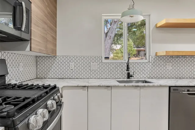 a kitchen with stainless steel appliances kitchen island granite countertop a refrigerator and a stove