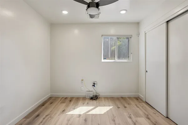 a view of a hallway with wooden floor and closet