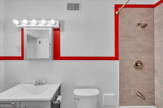 a bathroom with a sink mirror and toilet