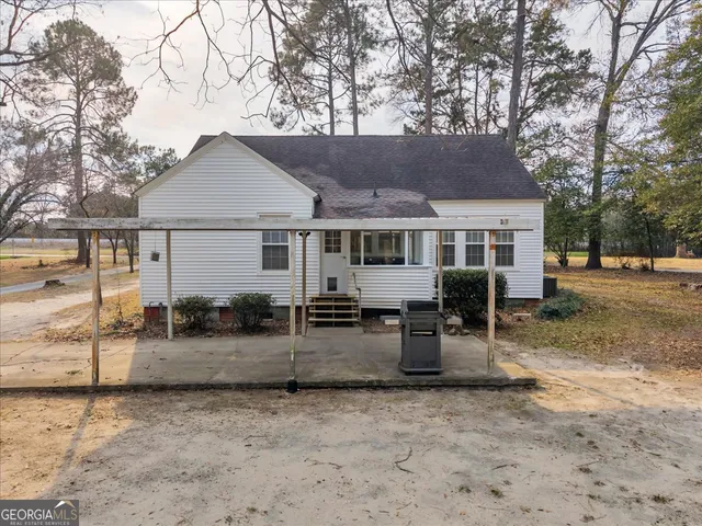 a view of a house with backyard and sitting area