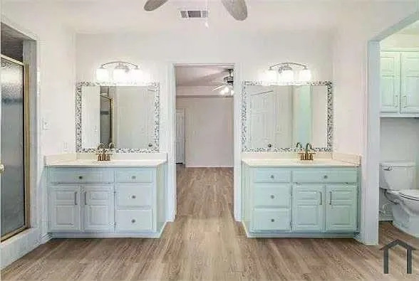 a bathroom with double vanity sink and a mirror