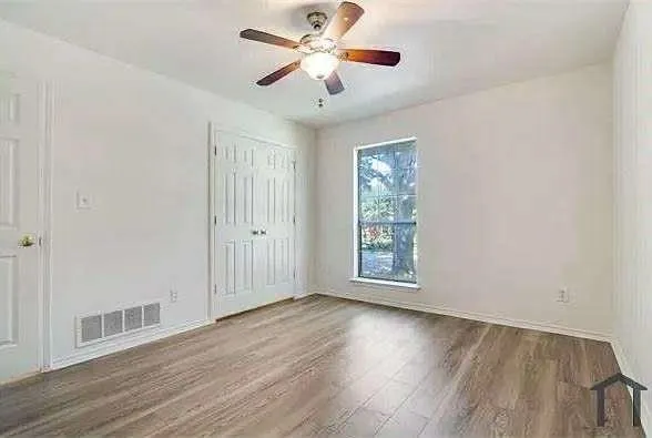 wooden floor in an empty room with a window