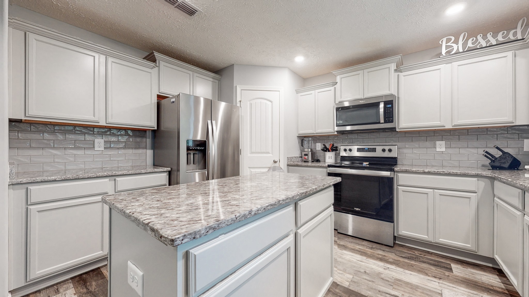 301 Homer Jackson Drive Smyrna, TN 37167 - Photo 5 of 27 a kitchen with kitchen island granite countertop a sink stove and refrigerator