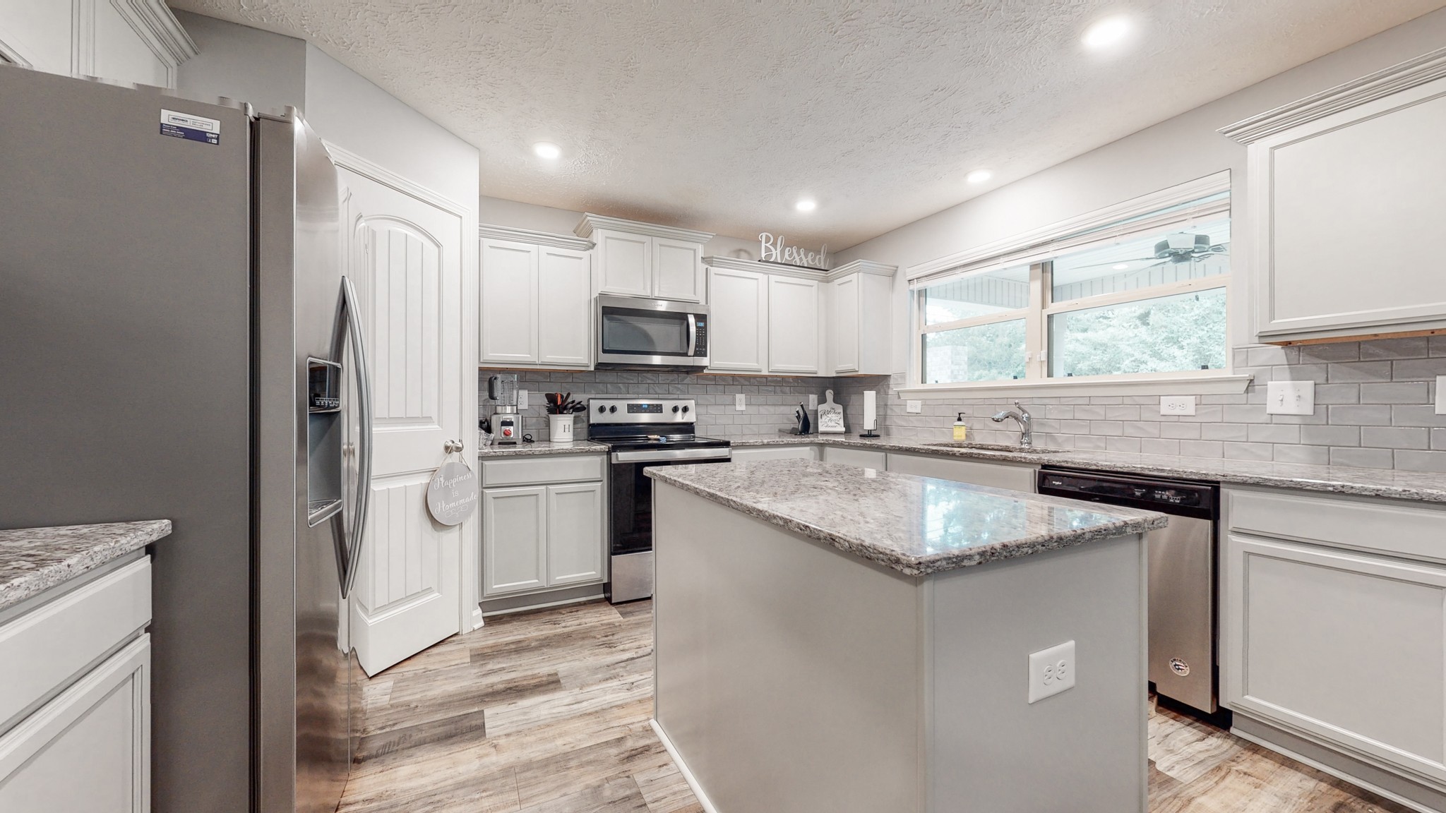 301 Homer Jackson Drive Smyrna, TN 37167 - Photo 7 of 27 a kitchen with kitchen island granite countertop a sink stove and refrigerator