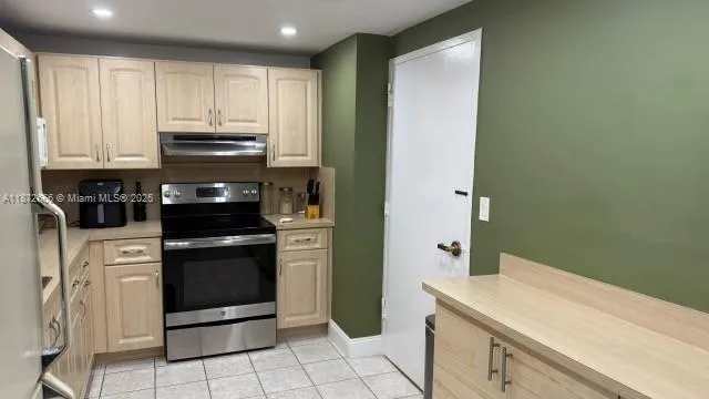 a kitchen with stainless steel appliances granite countertop a refrigerator and a stove