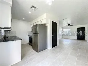 a kitchen with stainless steel appliances granite countertop a refrigerator and a sink