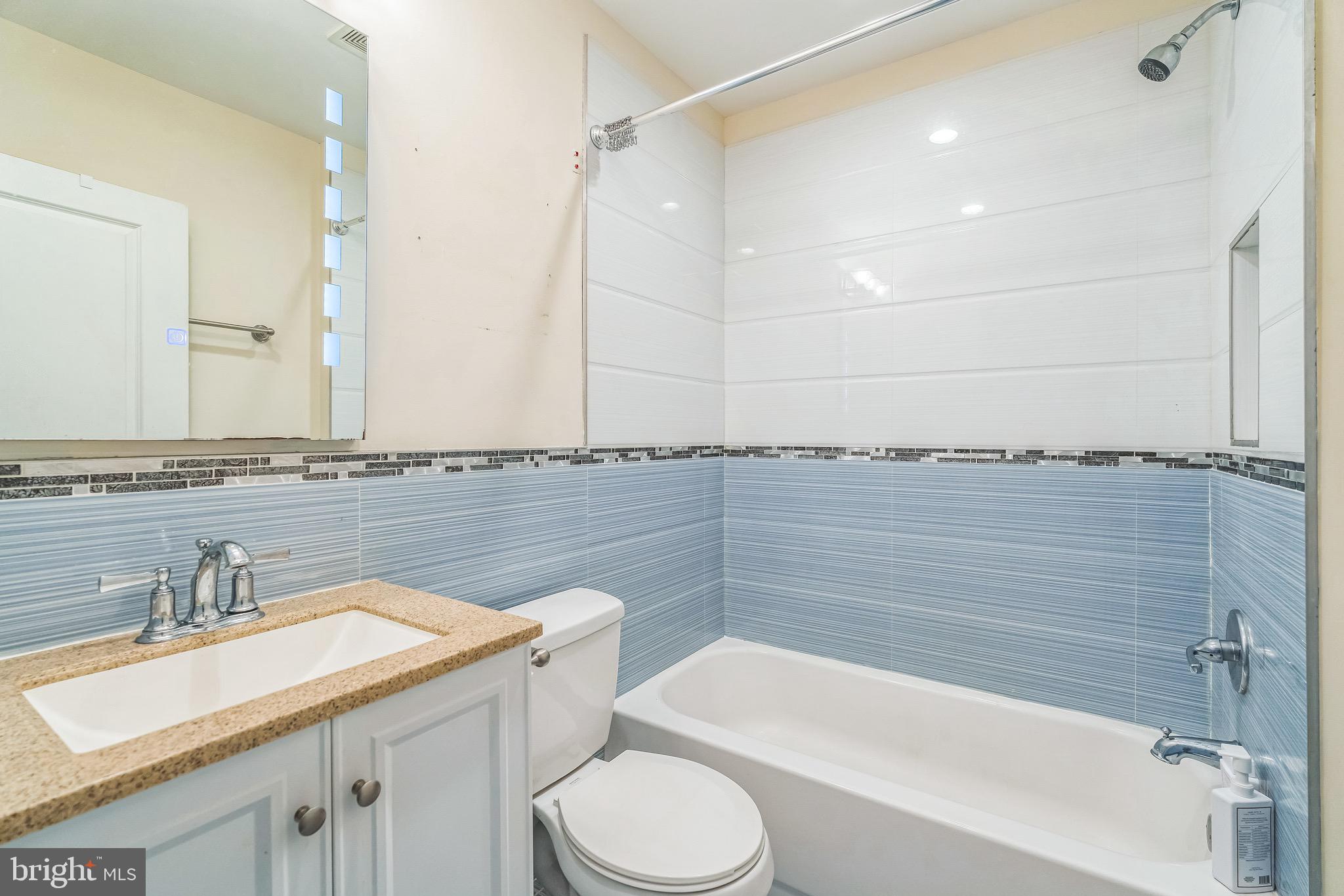 2233 Moore Street Philadelphia, PA 19145 - Photo 14 of 24 a bathroom with a granite countertop bathtub sink vanity mirror and toilet