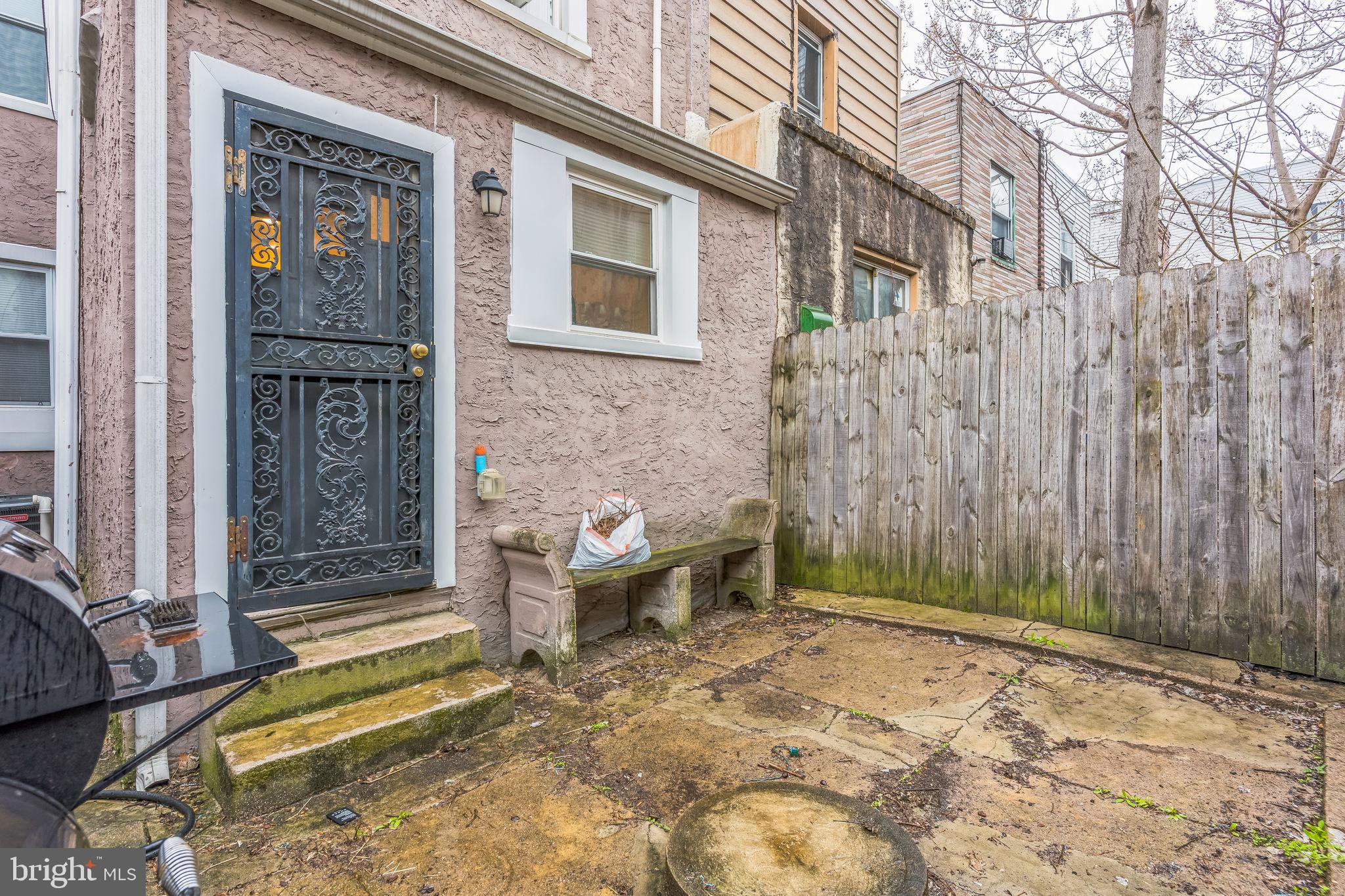2233 Moore Street Philadelphia, PA 19145 - Photo 23 of 24 a backyard of a house with barbeque oven table and chairs