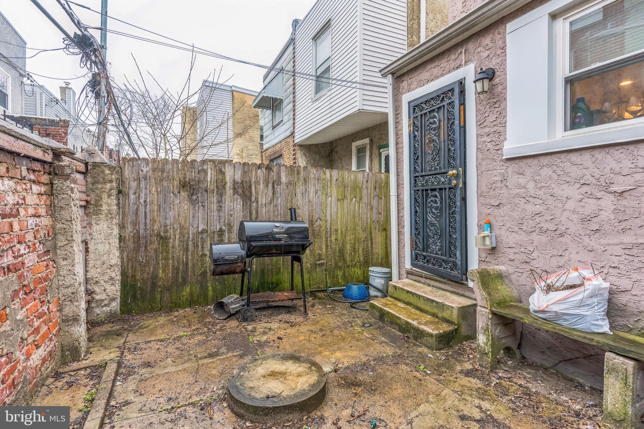 2233 Moore Street Philadelphia, PA 19145 - Photo 24 of 24 a backyard of a house with barbeque oven table and chairs