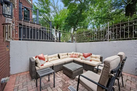 a roof deck with chairs and potted plants