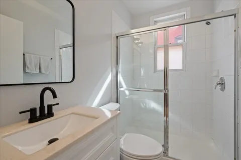 a bathroom with a sink a toilet and shower