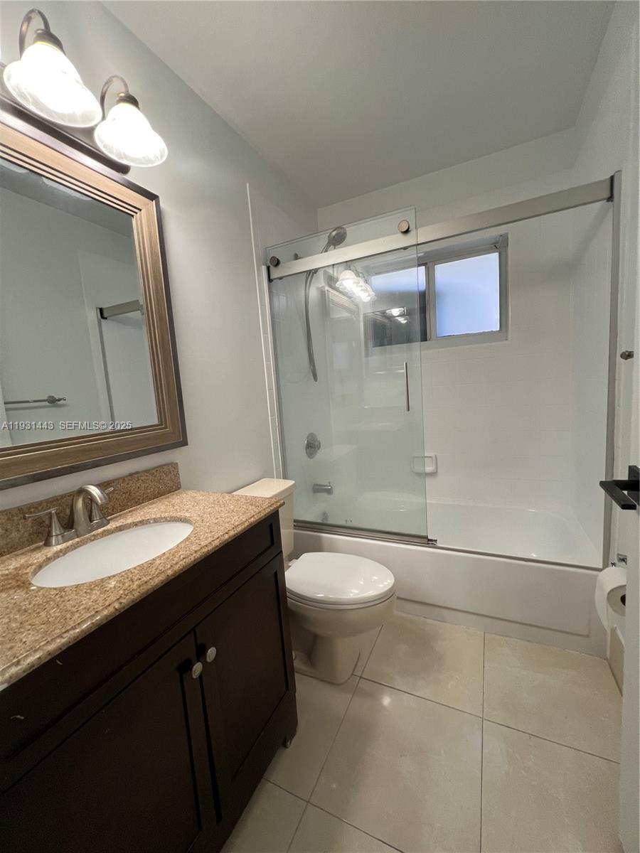 13721 Newport Manor Davie, FL 33325 - Photo 15 of 16 a bathroom with a granite countertop sink toilet and shower