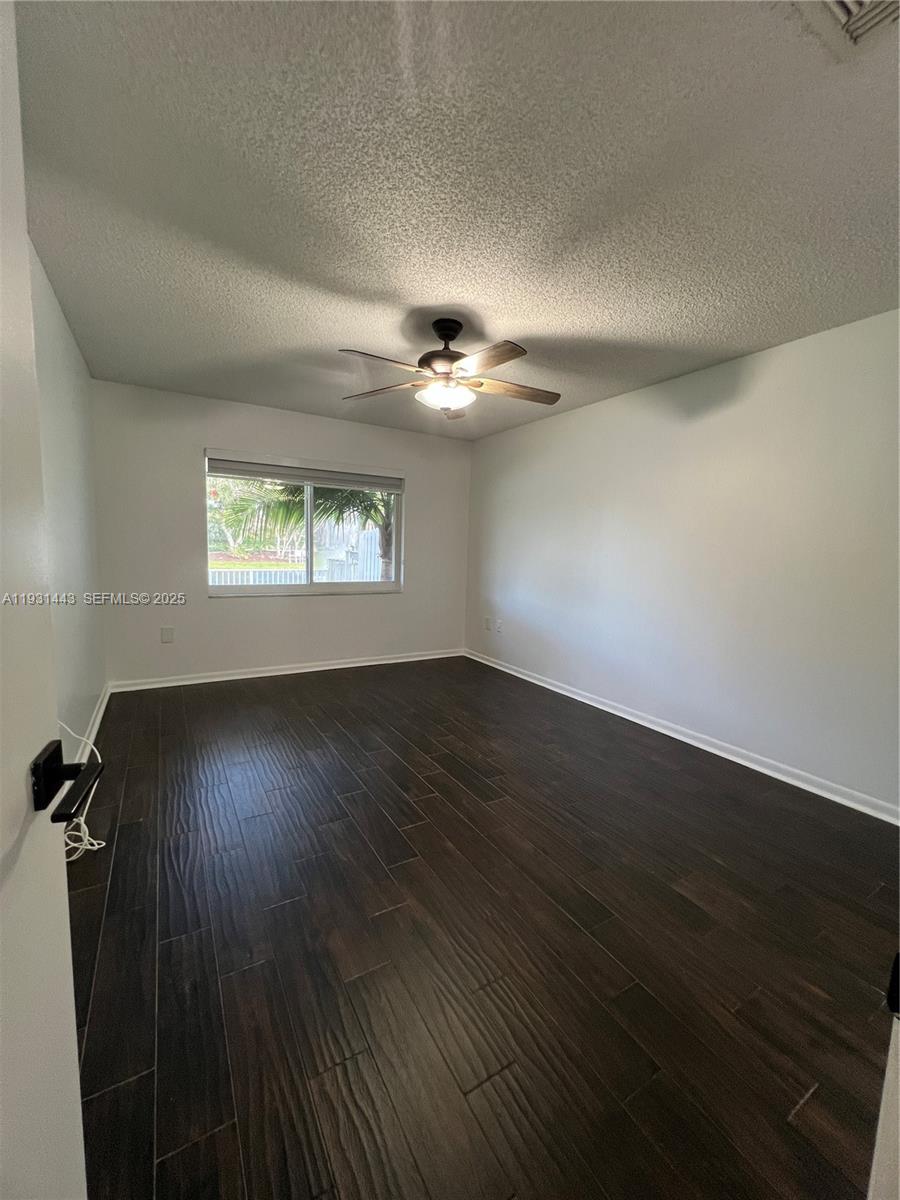 13721 Newport Manor Davie, FL 33325 - Photo 3 of 16 an empty room with wooden floor and windows