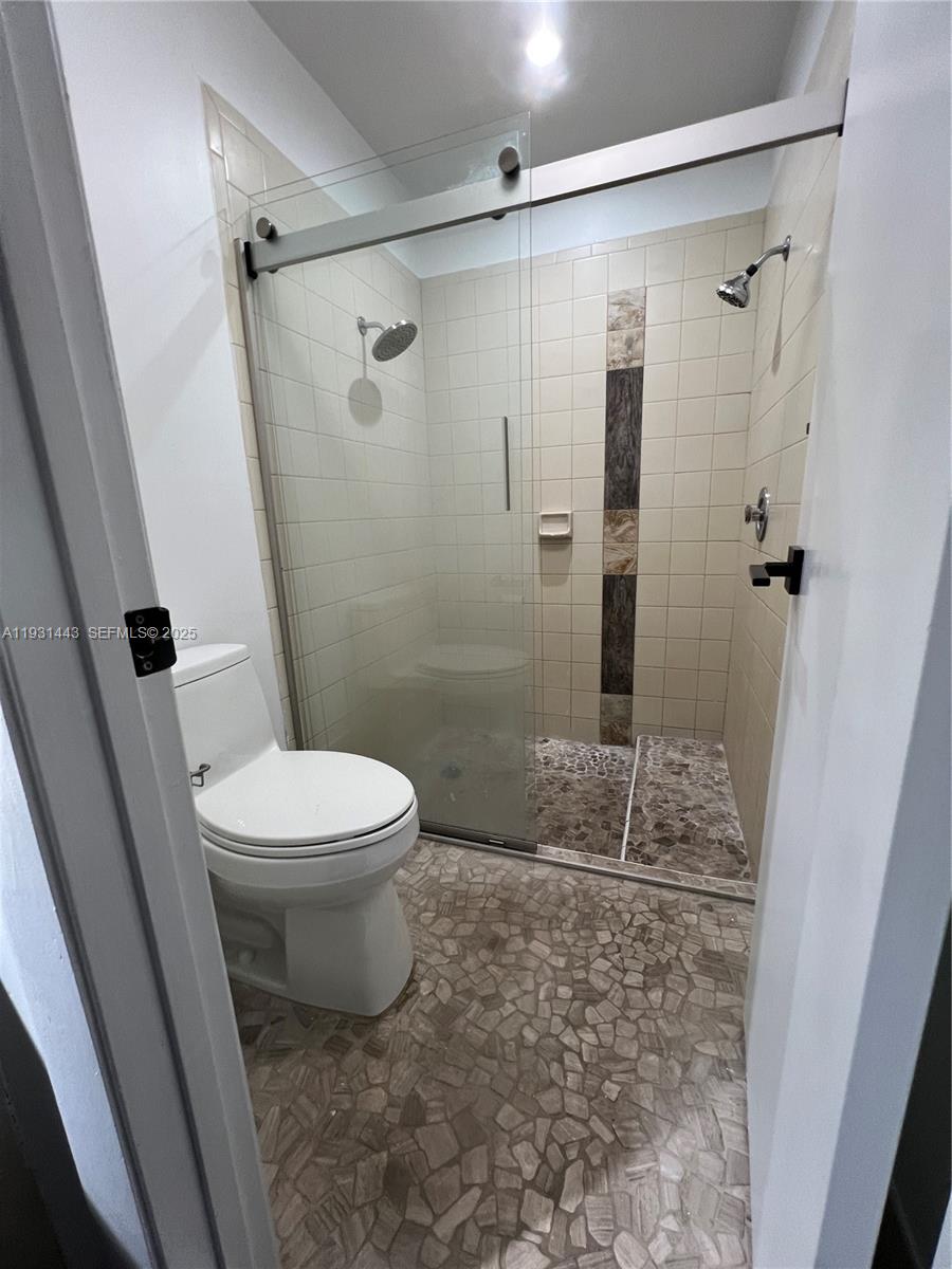 13721 Newport Manor Davie, FL 33325 - Photo 5 of 16 a bathroom with a granite countertop shower and a toilet