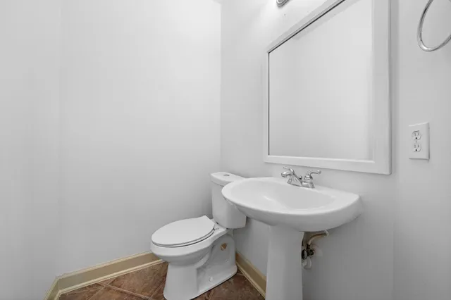 an empty room with chandelier fan and windows