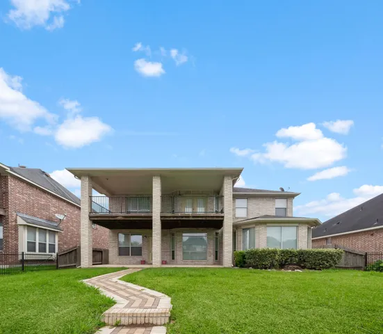 a front view of a house with a yard and trees
