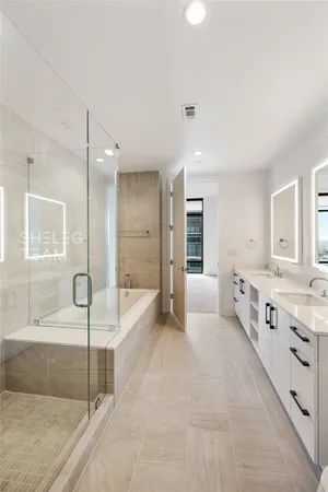 a large spacious bathroom with a granite countertop tub shower and mirror