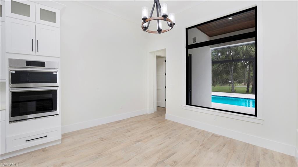 652 15th Street Southwest Naples, FL 34117 - Photo 11 of 47 a view of a hallway with wooden floor and kitchen