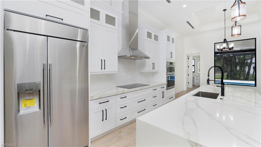 652 15th Street Southwest Naples, FL 34117 - Photo 13 of 47 a kitchen with stainless steel appliances kitchen island granite countertop a refrigerator and a stove top oven