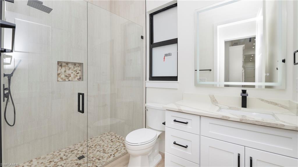652 15th Street Southwest Naples, FL 34117 - Photo 15 of 47 a bathroom with a granite countertop sink toilet and shower