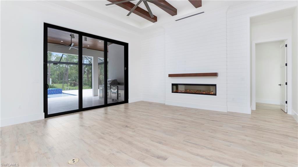 652 15th Street Southwest Naples, FL 34117 - Photo 9 of 47 a view of an empty room with a window and wooden floor