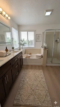 a spacious bathroom with a tub sink and mirror