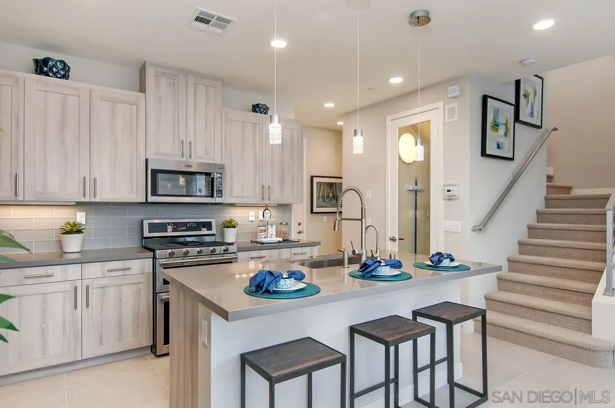 1189 Via Candelas Oceanside, CA 92056 - Photo 7 of 21 a kitchen with white cabinets and appliances
