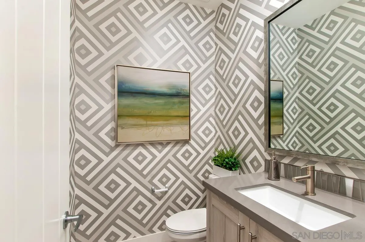 1189 Via Candelas Oceanside, CA 92056 - Photo 10 of 21 a bathroom with a sink a mirror and a toilet