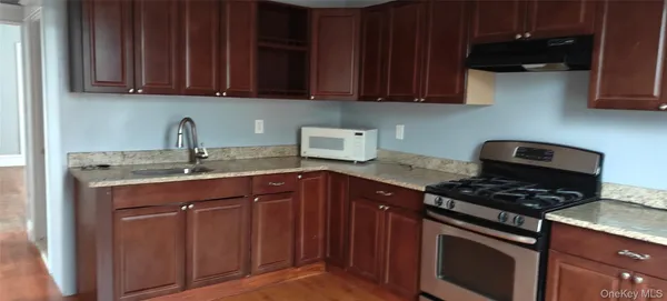 a kitchen with granite countertop a stove sink and cabinets