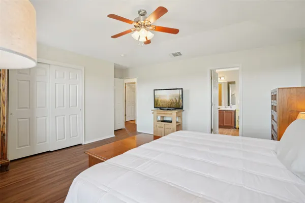 a bedroom with a bed and a flat tv screen on dresser