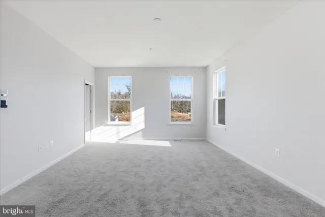 a view of a big room with windows and chandelier fan