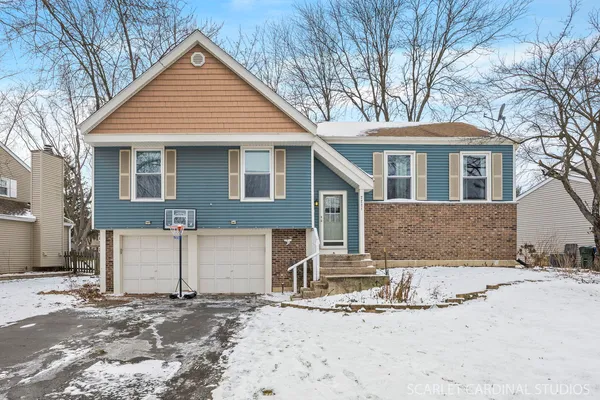 a front view of a house with a yard covered in snow