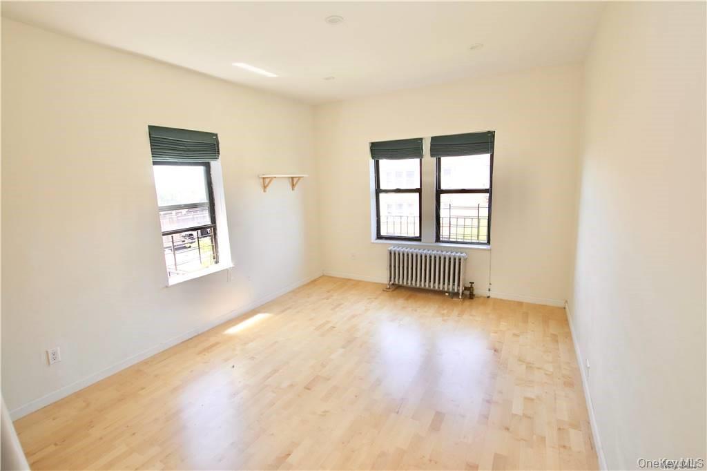 43-33 48th Street, Unit 6D Queens, NY 11104 - Photo 11 of 14 an empty room with windows