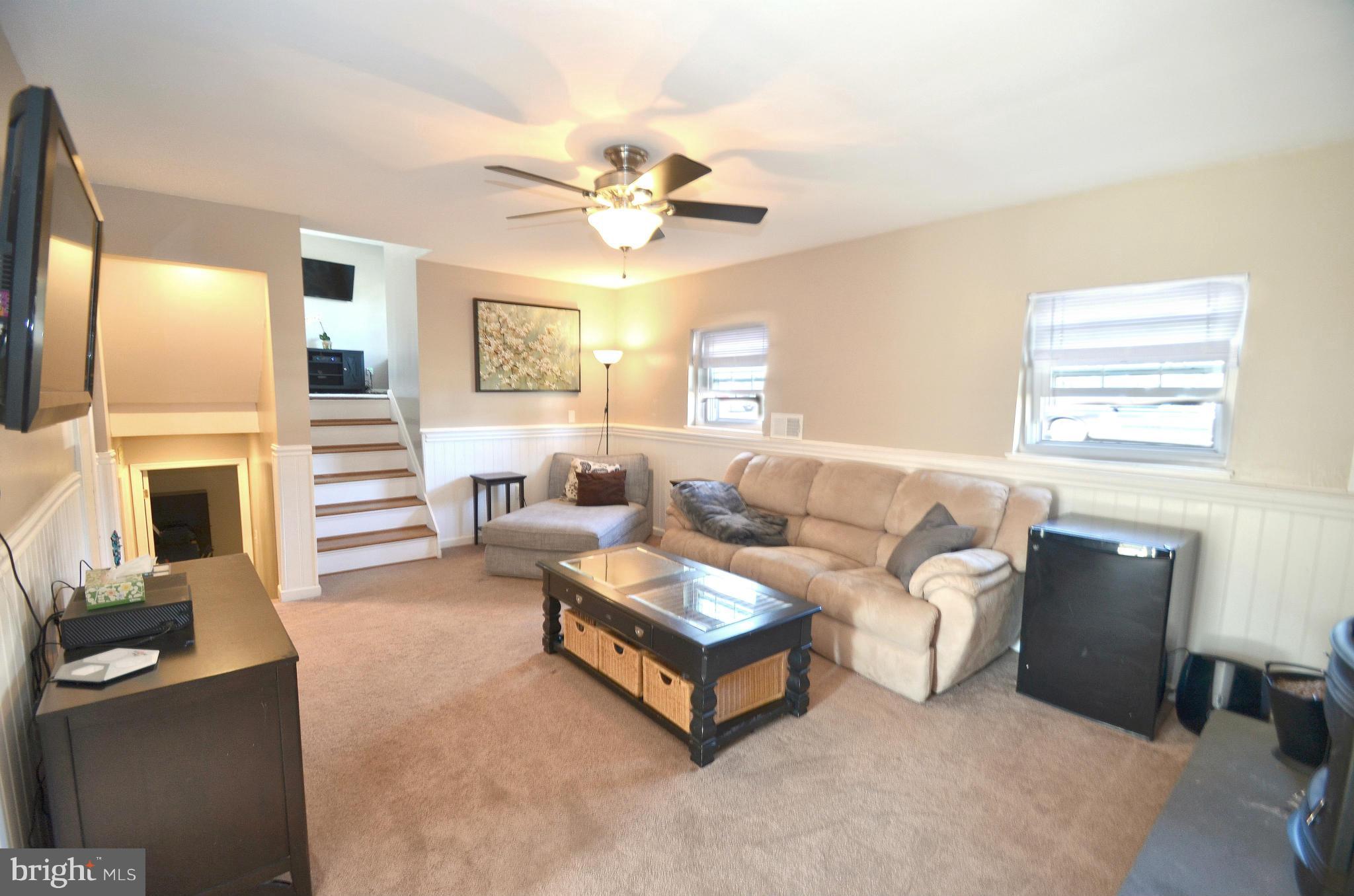 901 Beech Tree Road Severn, MD 21144 - Photo 17 of 27 a living room with furniture a fireplace and a flat screen tv