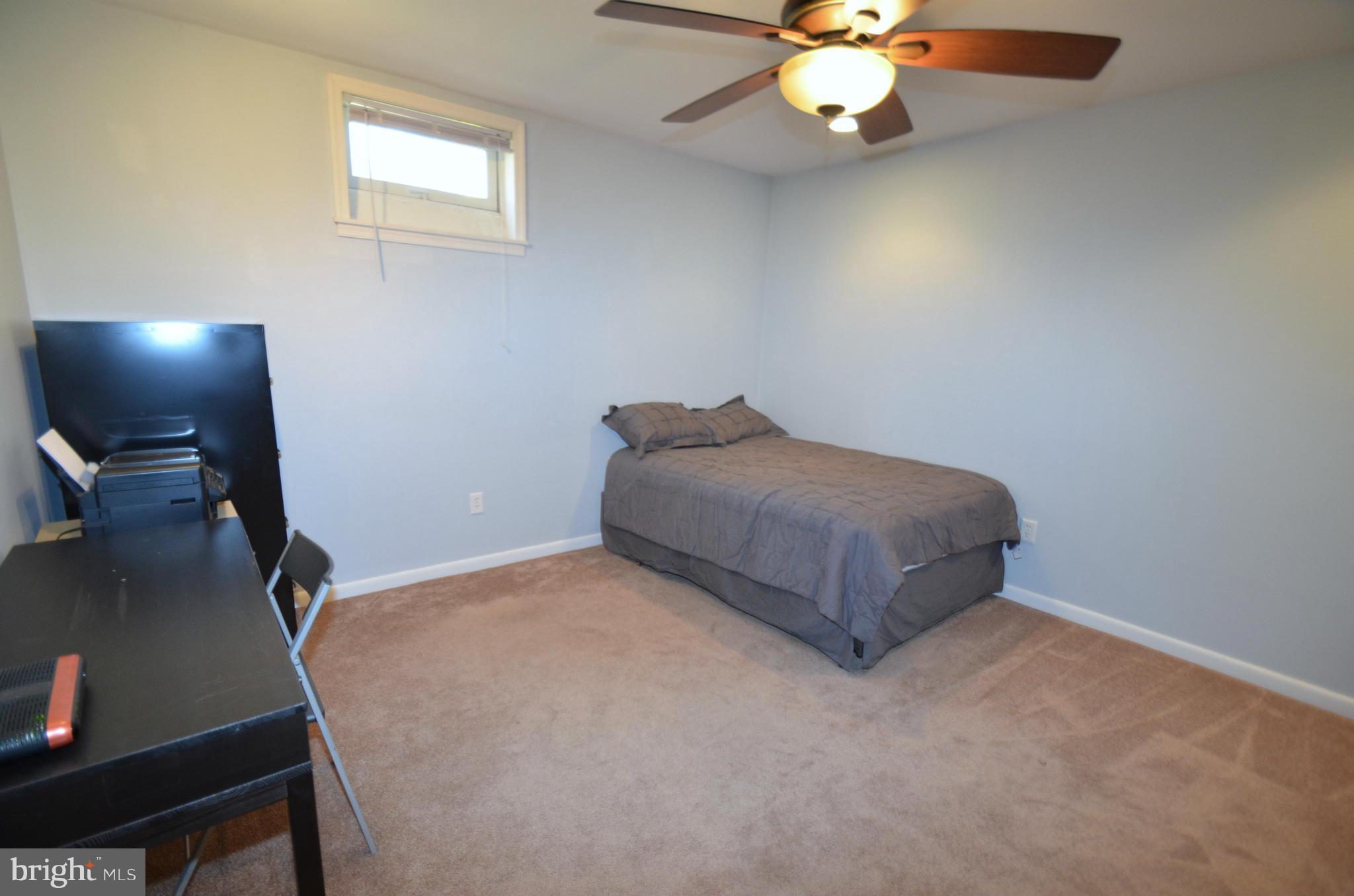 901 Beech Tree Road Severn, MD 21144 - Photo 22 of 27 a room with a bed and a chandelier
