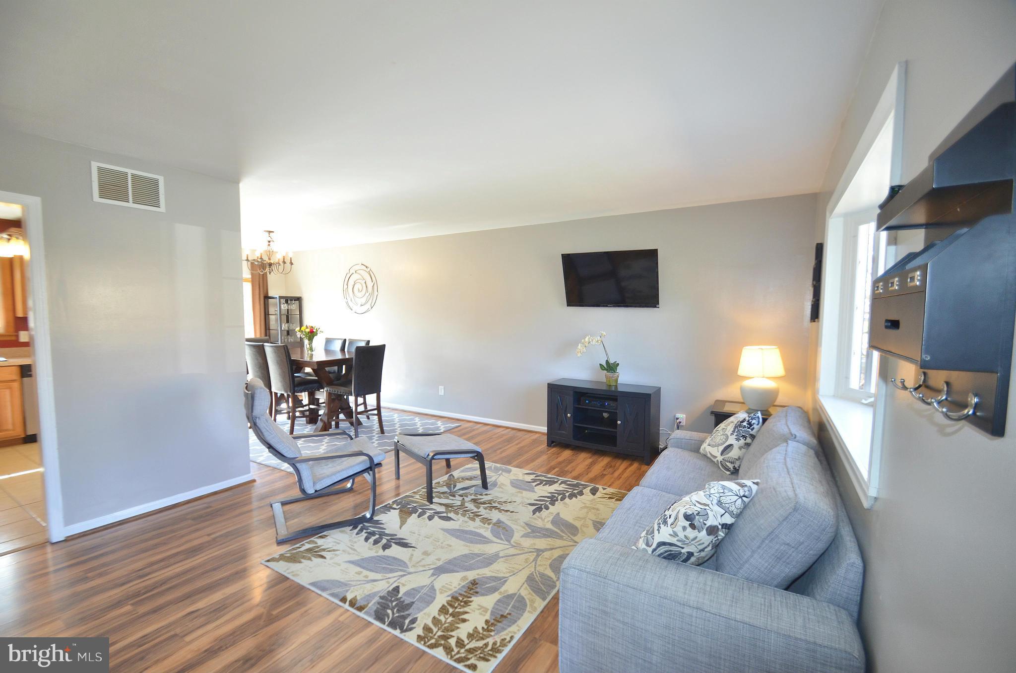 901 Beech Tree Road Severn, MD 21144 - Photo 4 of 27 a living room with furniture a dining table and a flat screen tv