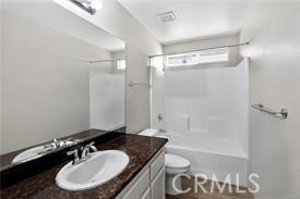 20726 Nisqually Road Apple Valley, CA 92308 - Photo 15 of 16 a bathroom with a granite countertop sink toilet a mirror and shower