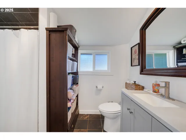 a bathroom with a toilet a sink and mirror