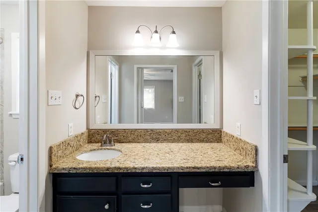 a bathroom with a granite countertop sink and a mirror
