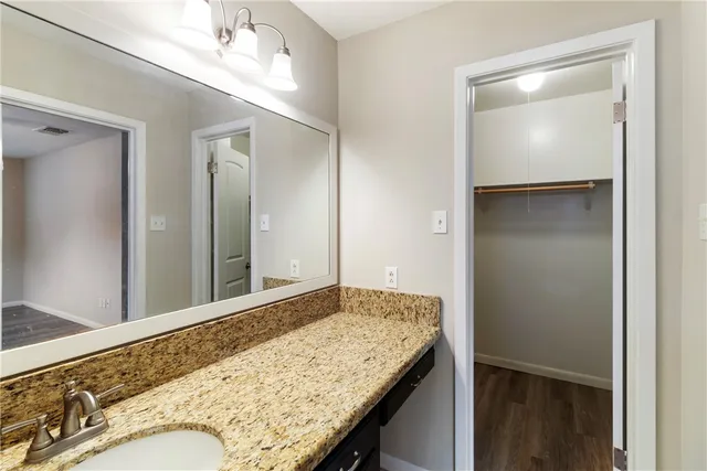 a bathroom with a granite countertop sink and a mirror