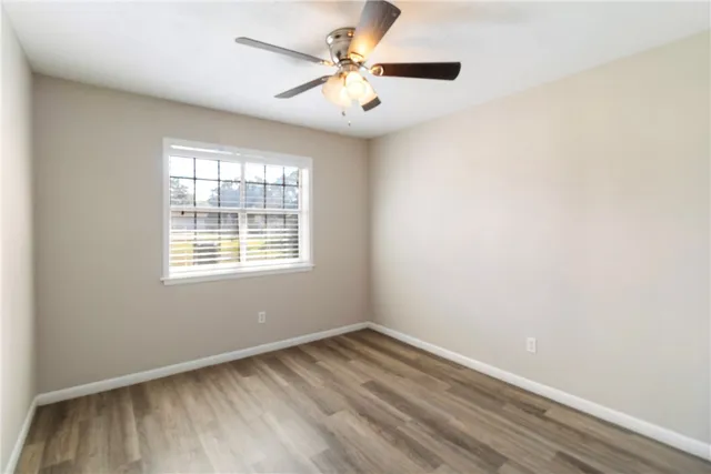 an empty room with a window and a ceiling fan