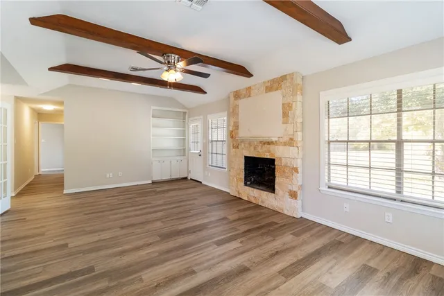 a view of empty room with wooden floor and fireplace