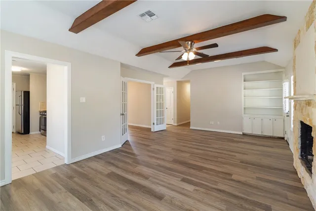 a view of an empty room with wooden floor