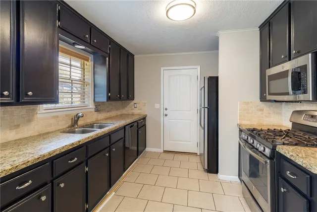 a kitchen with stainless steel appliances granite countertop a sink stove and refrigerator
